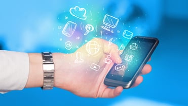 Hand holding smartphone with glowing multimedia icons