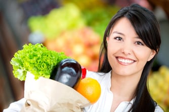 Woman grocery shopping and looking very happy