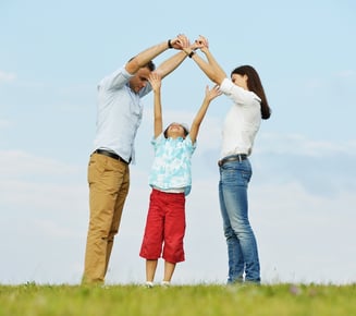 Young family on green summer grass meadow building dream new home