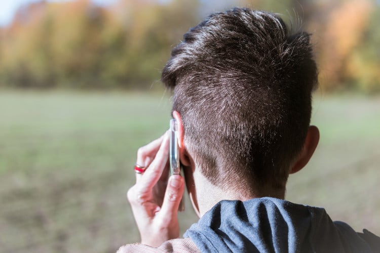 Featured image: person standing outdoors looking at a field, speaking on a mobile phone - Read full post: Canadian Perspectives on Environmental Noise Survey (CPENS)